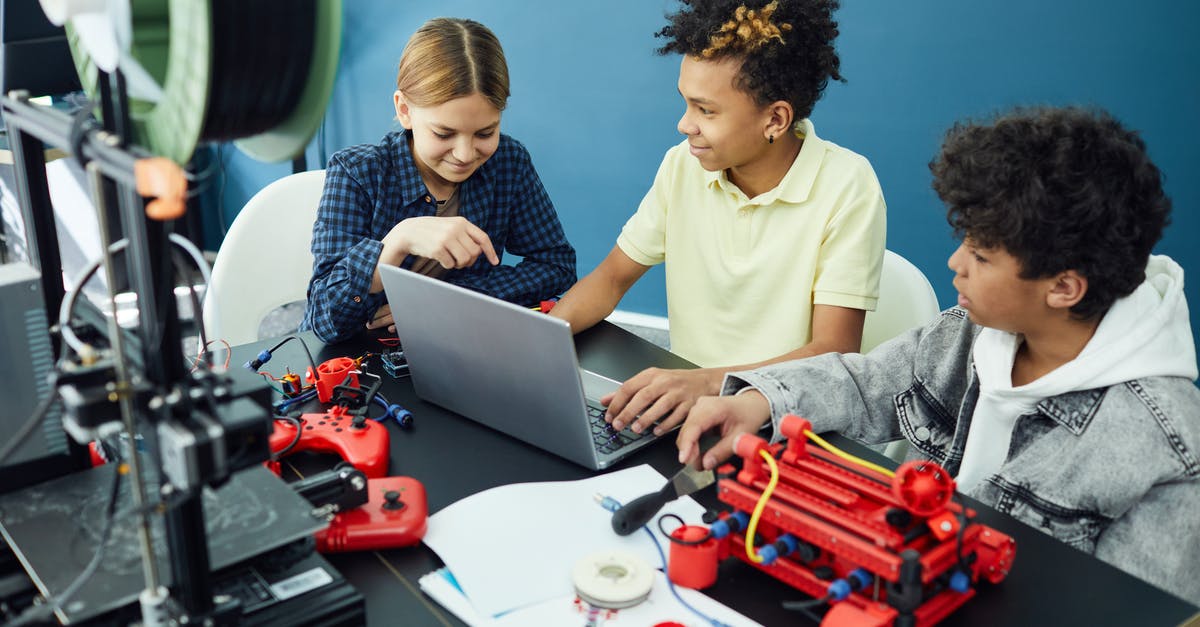 Flying with a Prusa Mendel 3d printer - Cheerful group of teenagers using laptop Flying with a Prusa Mendel 3d printer - Cheerful group of teenagers using laptop