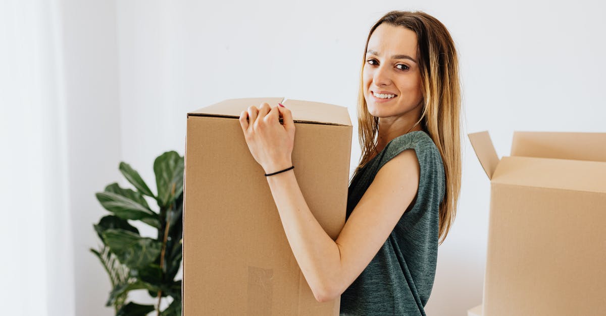 Foreign storage of a carry-on - Cheerful woman carrying packed carton box Foreign storage of a carry-on - Cheerful woman carrying packed carton box