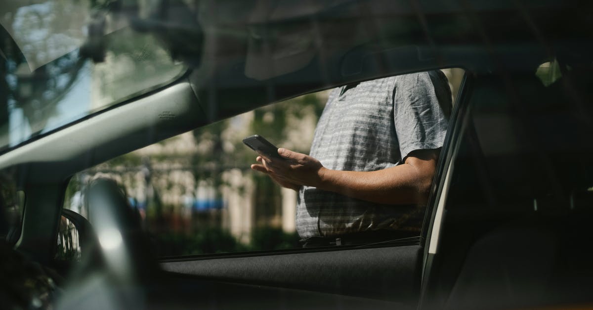 Forgot to send checklist with UK Visa Application - Man using smartphone near taxi car Forgot to send checklist with UK Visa Application - Man using smartphone near taxi car