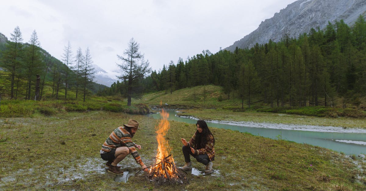 Former Gulag camps in Russia - Man and Woman Sitting on Grass Near Bonfire Former Gulag camps in Russia - Man and Woman Sitting on Grass Near Bonfire