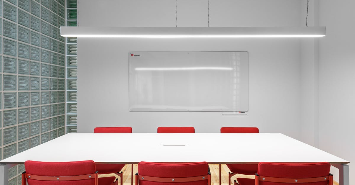 Free work place options in London - Interior of office with white table near red stools and whiteboard on wall near lamp and glass wall Free work place options in London - Interior of office with white table near red stools and whiteboard on wall near lamp and glass wall