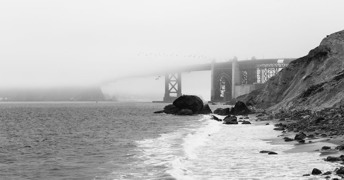 Freighter travel from the east coast of the U.S. to Copenhagen [closed] - Breathtaking black and white scenery stormy ocean with foamy waves washing rocky beach near famous Golden Gate Bridge hidden under thick fog in San Francisco