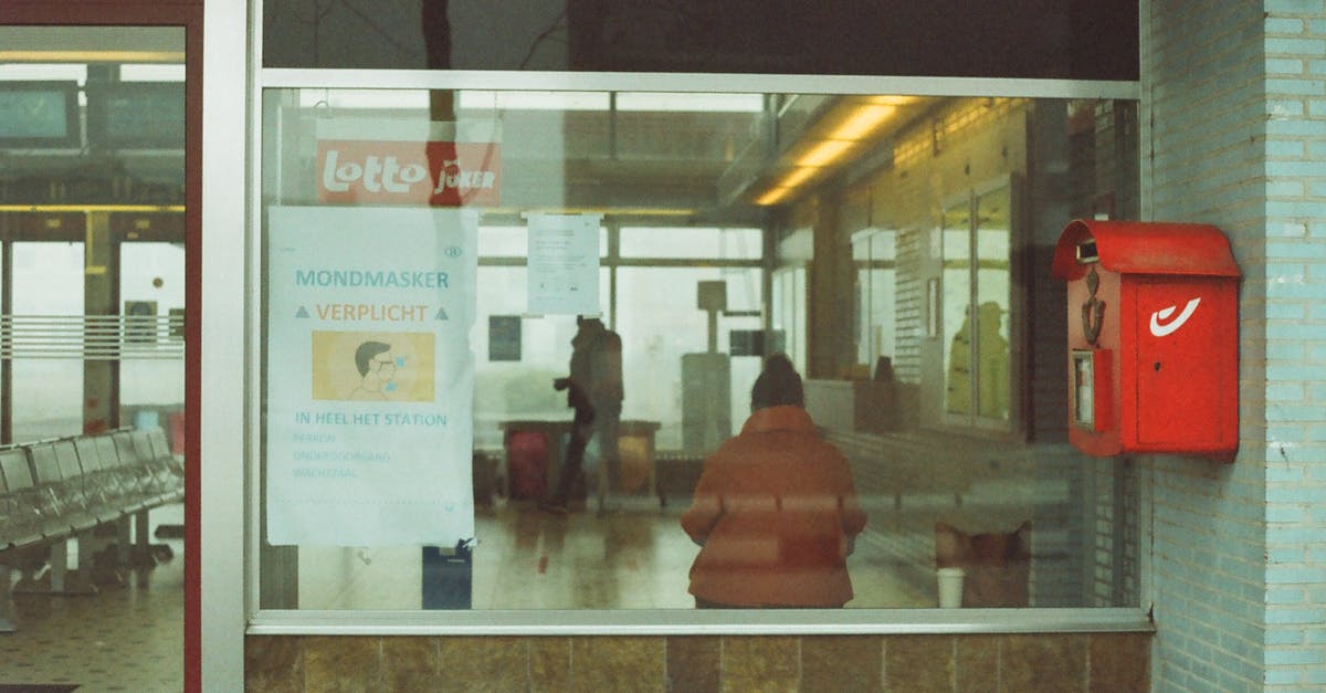 French train ticket (SNCF) cancelled at the last minute - Through glass of anonymous tourists in warm outerwear standing in waiting room of modern railway station French train ticket (SNCF) cancelled at the last minute - Through glass of anonymous tourists in warm outerwear standing in waiting room of modern railway station