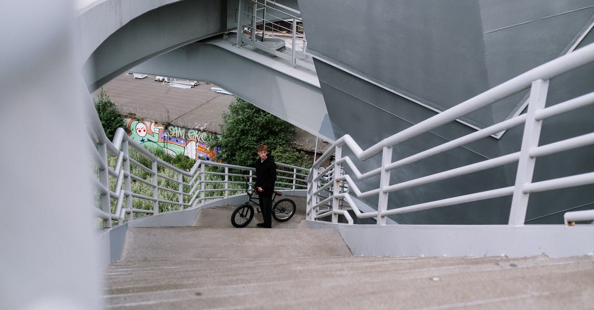From Chek Lap Kok Airport to Macau via the mega bridge - Man in Red Jacket and Black Pants Walking on White Concrete Stairs From Chek Lap Kok Airport to Macau via the mega bridge - Man in Red Jacket and Black Pants Walking on White Concrete Stairs