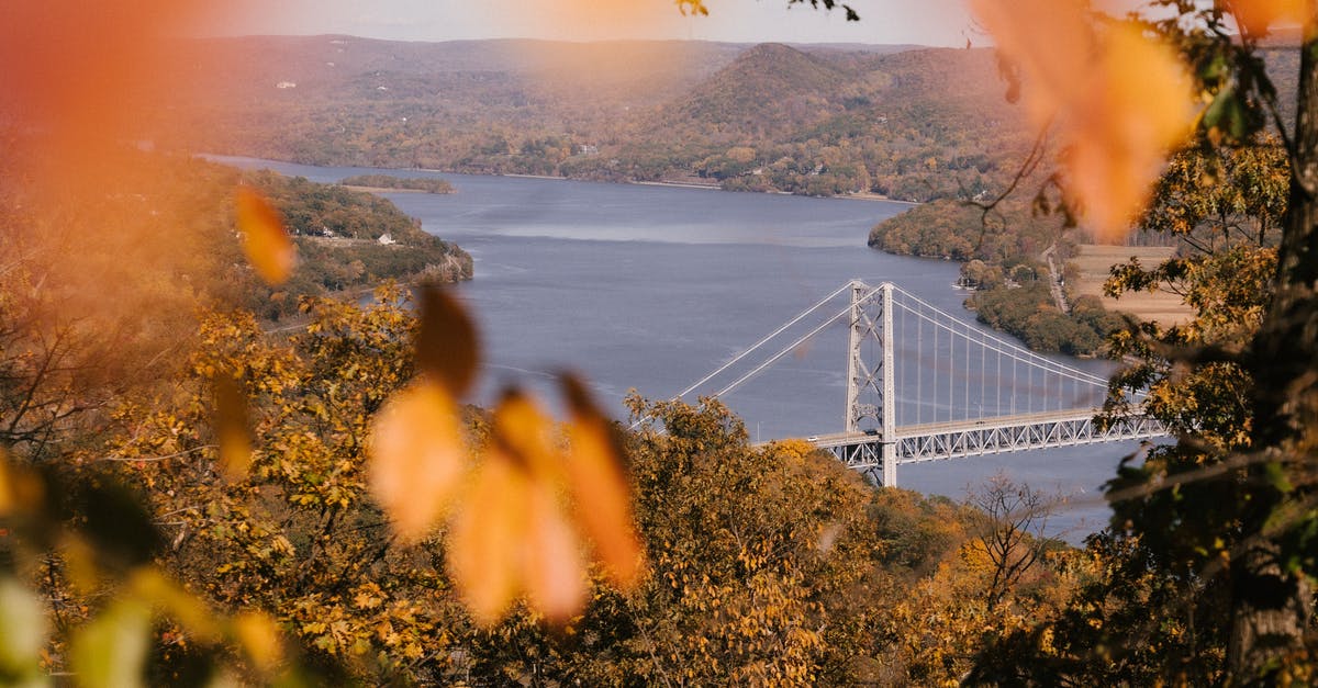 From what point could you view the most US states? - Picturesque scenery of Bear Mountain Bridge over river surrounded by hills covered with lush autumn forests