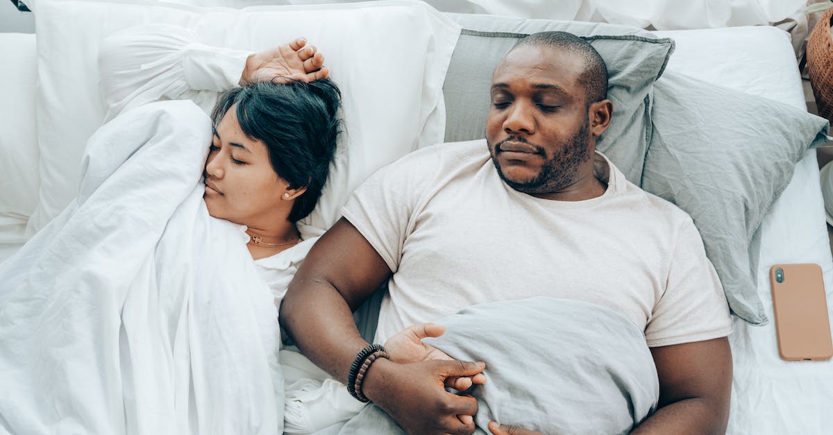 Fuerteventura surfing and quiet romantic accommodation [closed] - Young multiethnic spouses sleeping in bed holding hands