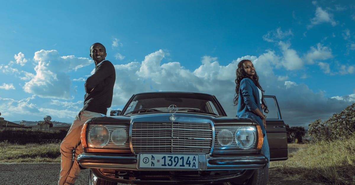 Full listing of rental car category - Stylish black couple standing near retro car in countryside Full listing of rental car category - Stylish black couple standing near retro car in countryside