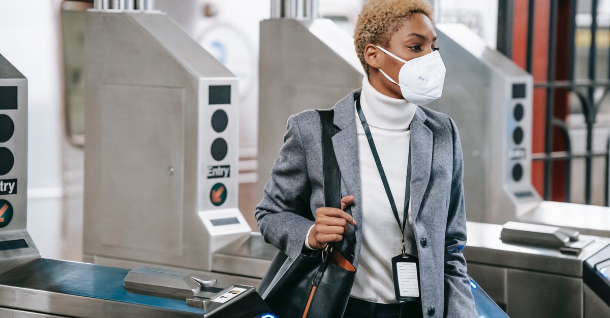 Gate pass at Atlanta Hartsfield - Calm attractive African American female in stylish formal wear and protective mask passing through turnstile gates in underground station Gate pass at Atlanta Hartsfield - Calm attractive African American female in stylish formal wear and protective mask passing through turnstile gates in underground station
