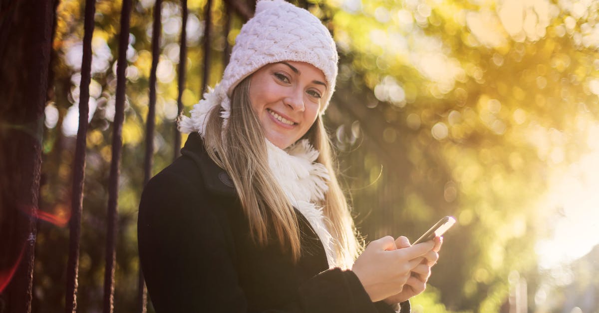 Gate to gate electronic device usage on AmericanConnection/Chautauqua Airlines? - Smiling woman chatting on smartphone in park Gate to gate electronic device usage on AmericanConnection/Chautauqua Airlines? - Smiling woman chatting on smartphone in park
