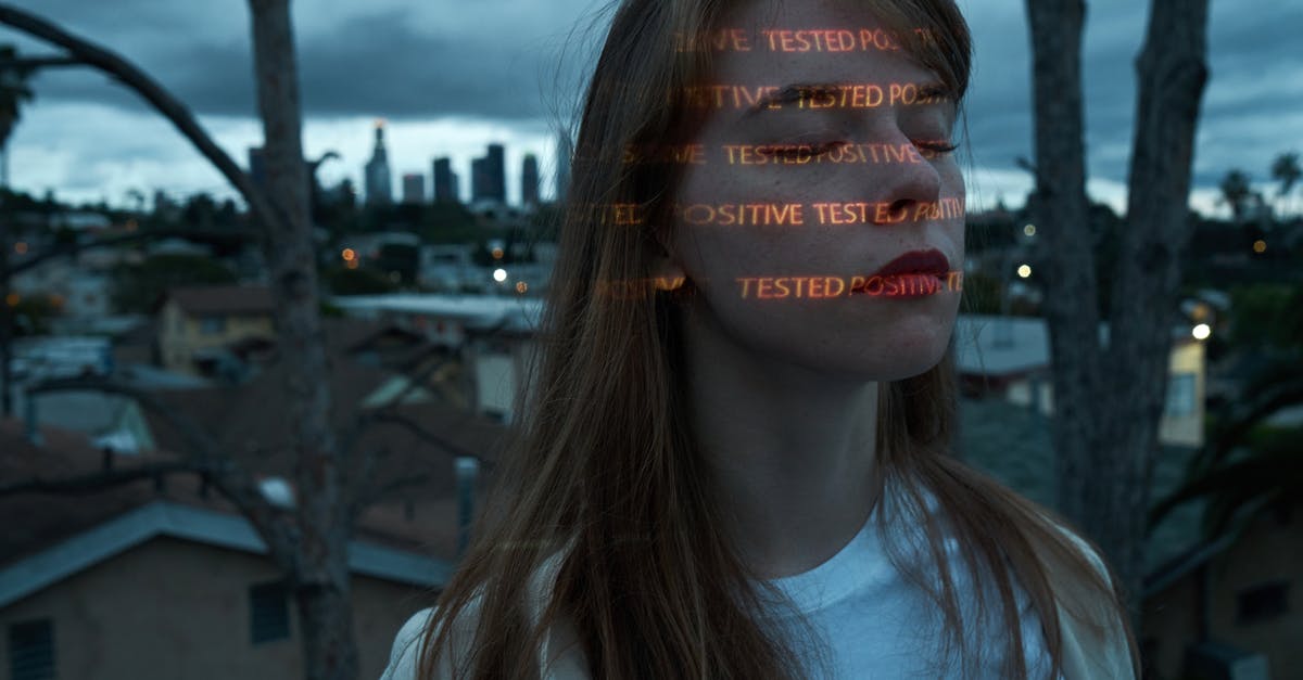 Germany: What happens if you test Covid positive on arrival - Calm woman with Positive Tested words on face on roof against cityscape Germany: What happens if you test Covid positive on arrival - Calm woman with Positive Tested words on face on roof against cityscape