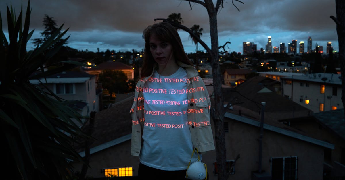 Germany: What happens if you test Covid positive on arrival - Serious woman on night rooftop with respirator Germany: What happens if you test Covid positive on arrival - Serious woman on night rooftop with respirator