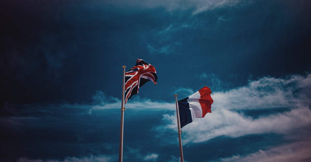 Getting a package from the US while travelling through South Europe - Waving flags of France and United Kingdom against blue sky Getting a package from the US while travelling through South Europe - Waving flags of France and United Kingdom against blue sky