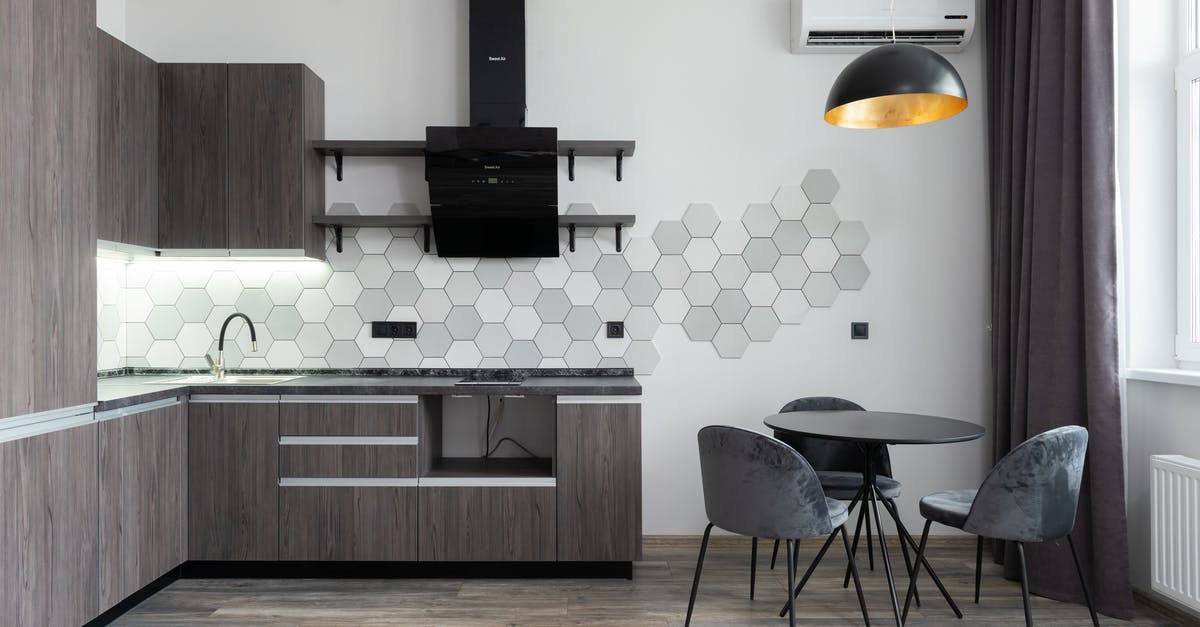 Getting a refund from TAP Air Portugal related to COVID-19 - Creative design of kitchen with cupboards and cabinets under hood against table with chairs in daylight at home