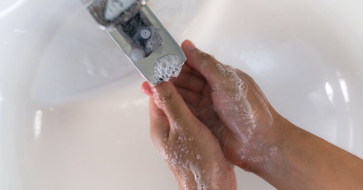 Getting a refund from TAP Air Portugal related to COVID-19 - Crop person washing hands over white sink