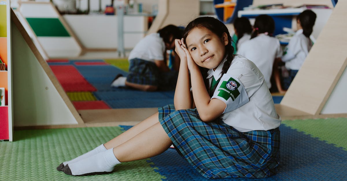 Getting around in Thailand without knowing Thai - Thai Girl in School Uniform Sitting on Ground Looking at Camera Getting around in Thailand without knowing Thai - Thai Girl in School Uniform Sitting on Ground Looking at Camera