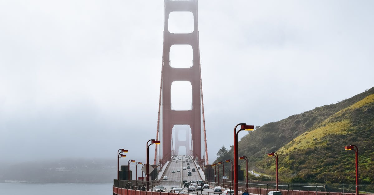 Getting around San Francisco on a 3-day trip - Golden Gate Bridge with cars driving on roadway along green hills in dense fog Getting around San Francisco on a 3-day trip - Golden Gate Bridge with cars driving on roadway along green hills in dense fog