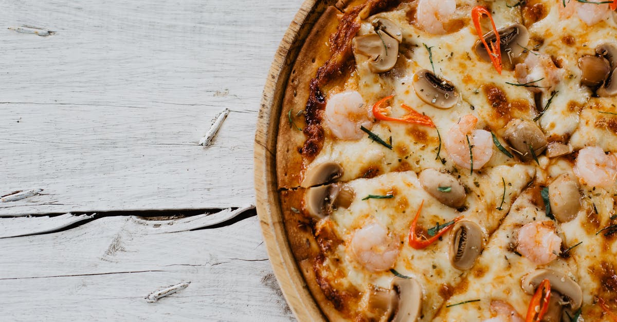 Getting Dutch Schengen visa from the Italian embassy - Appetizing pizza with shrimps and champignon on wooden table Getting Dutch Schengen visa from the Italian embassy - Appetizing pizza with shrimps and champignon on wooden table