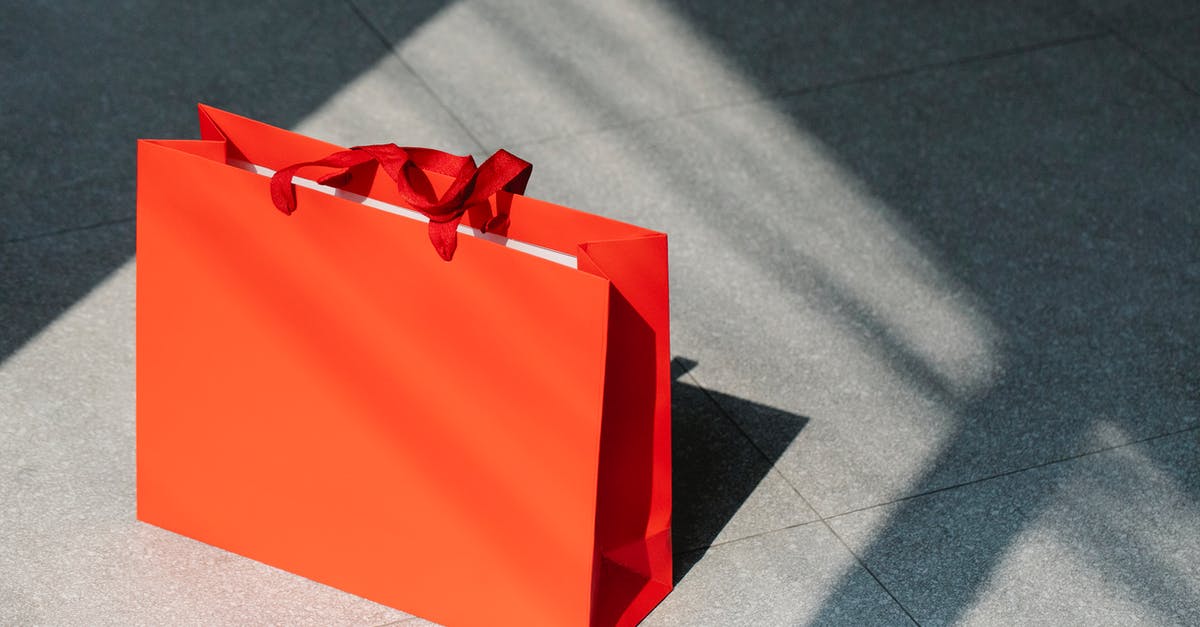 Getting from Toronto to New York - Red paper shopping bag on gray ground Getting from Toronto to New York - Red paper shopping bag on gray ground