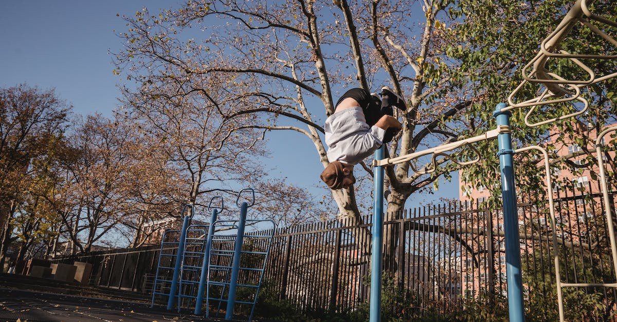 Getting from Victoria Falls airport to town - From below full body of unrecognizable male doing parkour while backflip in park near metal turnstile in street in sunny autumn day near trees with fence under blue cloudless sky Getting from Victoria Falls airport to town - From below full body of unrecognizable male doing parkour while backflip in park near metal turnstile in street in sunny autumn day near trees with fence under blue cloudless sky