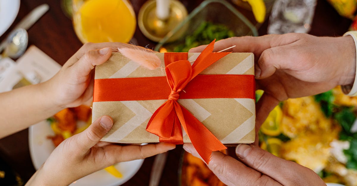 Gift giving in Korea: Do I have to wrap snacks? - Close-Up Shot of Two People Holding a Wrapped Gift with a Ribbon Gift giving in Korea: Do I have to wrap snacks? - Close-Up Shot of Two People Holding a Wrapped Gift with a Ribbon