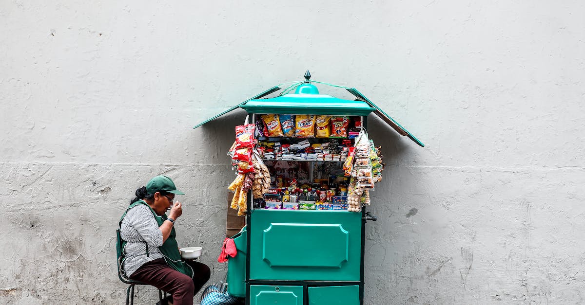 Gluten-free eating in Peru - Woman Eating While Seated Next to Mobile Shop Cart Gluten-free eating in Peru - Woman Eating While Seated Next to Mobile Shop Cart