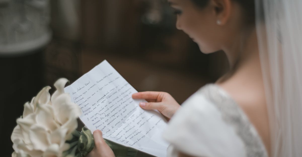 Going back to the USA on ESTA after K1 visa and marriage - Back view of crop charming bride in white dress and veil reading wedding vow on paper sheet with bouquet of arum lilies during weeding ceremony