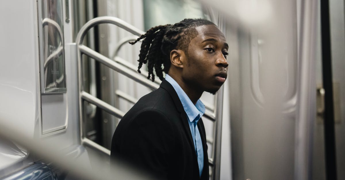 Good aurora viewing areas around Tromso accessible by public transport? - Side view of young stylish black man in formal wear with dreadlocks sitting on train seat and looking away with expression of slight interest on face Good aurora viewing areas around Tromso accessible by public transport? - Side view of young stylish black man in formal wear with dreadlocks sitting on train seat and looking away with expression of slight interest on face