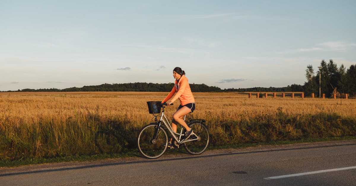 Good route for a 1-day bike trip around Amsterdam - Woman riding bicycle on road against countryside field Good route for a 1-day bike trip around Amsterdam - Woman riding bicycle on road against countryside field