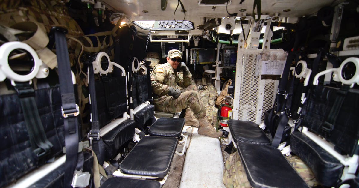 Greyhound Ticket Change $20 Fee for Military Personnel - Man in Soldier Suit Sitting in Black Leather Seat Greyhound Ticket Change $20 Fee for Military Personnel - Man in Soldier Suit Sitting in Black Leather Seat