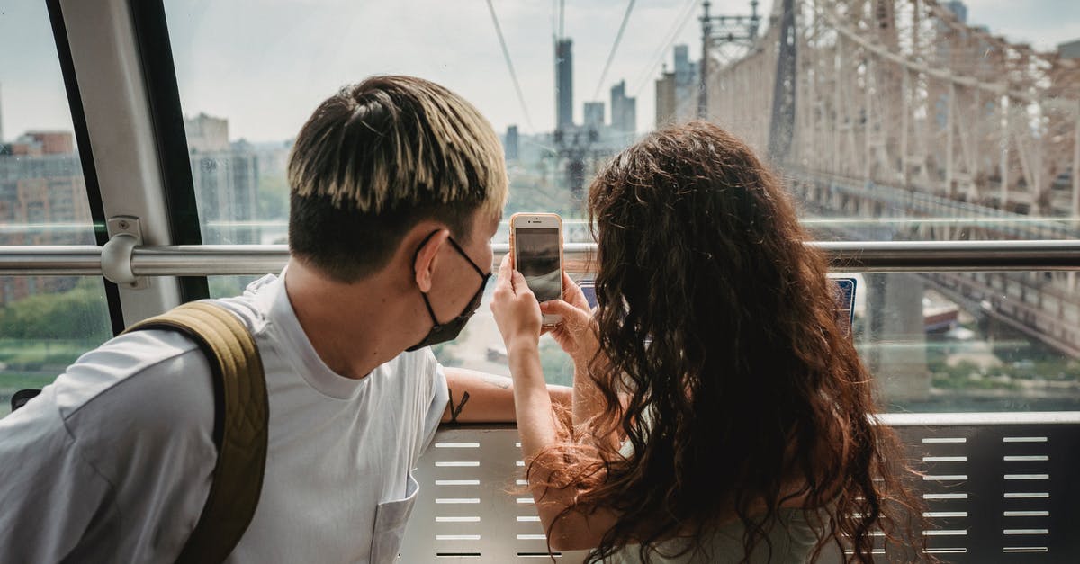 Has anyone used a grip a zip to prevent theft (airports and hotels) while traveling? [closed] - Young couple in protective mask taking photo on smartphone while riding together on cableway during vacation