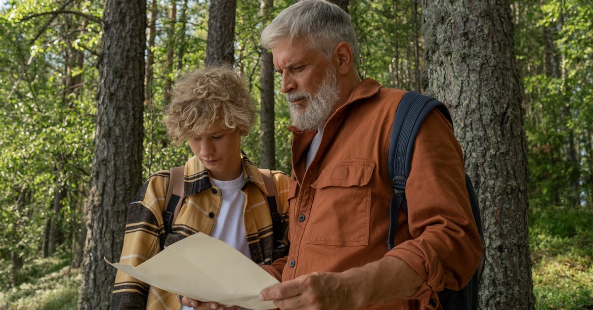 Hiking map for Hokkaido and/or other resources - Grandfather and Grandson with Map during Hiking through Forest Hiking map for Hokkaido and/or other resources - Grandfather and Grandson with Map during Hiking through Forest
