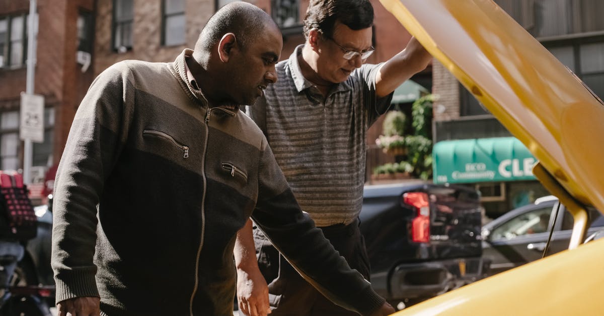 Homestays and a driver in Sri Lanka - will accommodation be a problem? - Focused multiracial male friends in casual clothes standing near opened hood of vehicle and looking at details Homestays and a driver in Sri Lanka - will accommodation be a problem? - Focused multiracial male friends in casual clothes standing near opened hood of vehicle and looking at details