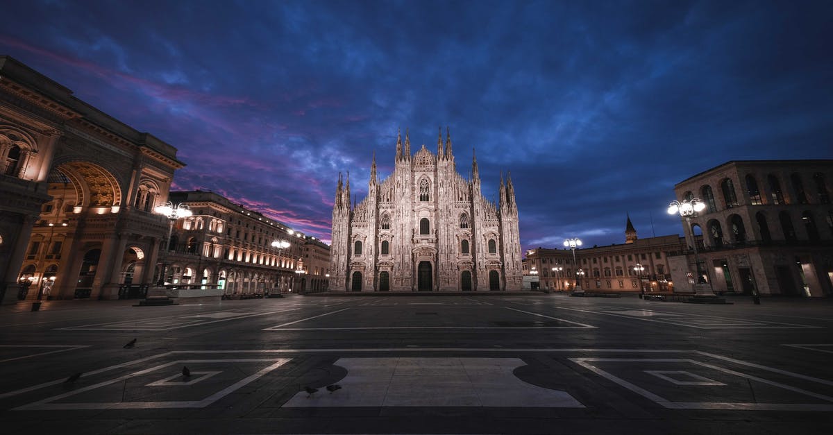 Hosting foreign minors in Switzerland and Italy - Low angle of aged masonry church exterior near square and buildings under bright sky in evening in Italy Hosting foreign minors in Switzerland and Italy - Low angle of aged masonry church exterior near square and buildings under bright sky in evening in Italy