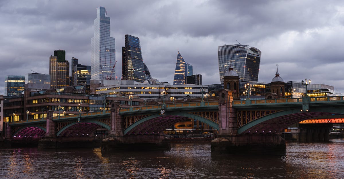 Housewife UK Visit Visa Finance Questions - Bridge with glowing lights crossing calm Thames river located against contemporary famous multistory office buildings in London on evening time Housewife UK Visit Visa Finance Questions - Bridge with glowing lights crossing calm Thames river located against contemporary famous multistory office buildings in London on evening time