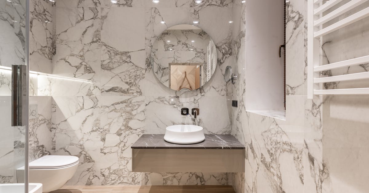 How am I supposed to keep a toilet bowl clean without a toilet brush? - Interior of modern bathroom with round mirror hanging on marble wall and white ceramic sink and toilet bowl How am I supposed to keep a toilet bowl clean without a toilet brush? - Interior of modern bathroom with round mirror hanging on marble wall and white ceramic sink and toilet bowl