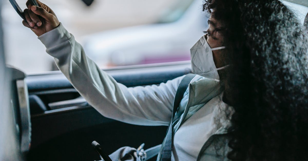 How are connection complications on a single KLM+Kenya Airways itinerary handled? - Side view of anonymous young African American female passenger in casual clothes and protective mask holding handle and looking away while sitting on backseat of taxi with smartphone in hand How are connection complications on a single KLM+Kenya Airways itinerary handled? - Side view of anonymous young African American female passenger in casual clothes and protective mask holding handle and looking away while sitting on backseat of taxi with smartphone in hand