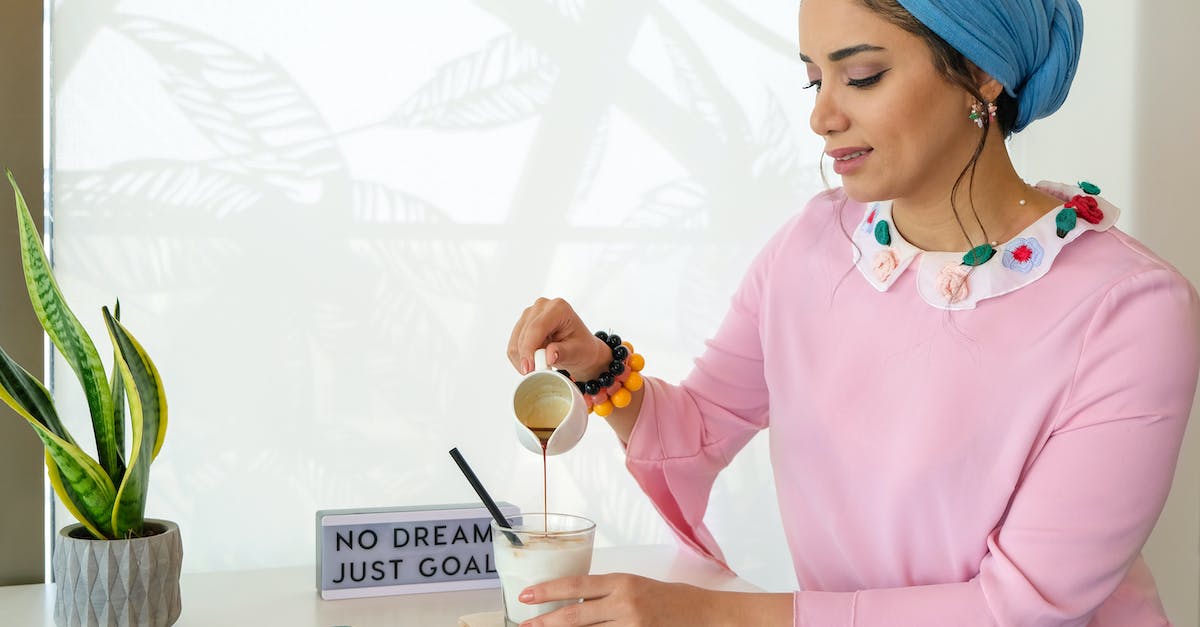 How are customs duties handled by the Fedex "Baggage Free" service? - Woman Holding Ceramic Mug Pouring Liquid on Glass on the Table
