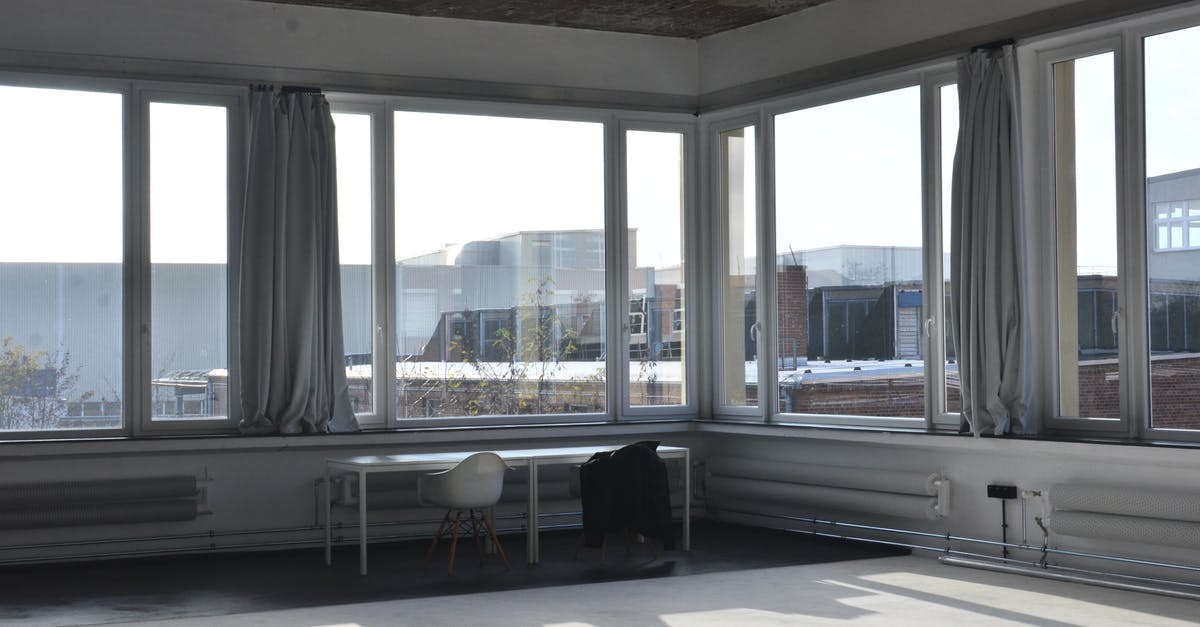 How big are Premier Inn Hub "Bigger" rooms? - Chairs placed at table near big window with curtain and modern cityscape view with buildings in minimalistic empty room in sunlight How big are Premier Inn Hub "Bigger" rooms? - Chairs placed at table near big window with curtain and modern cityscape view with buildings in minimalistic empty room in sunlight