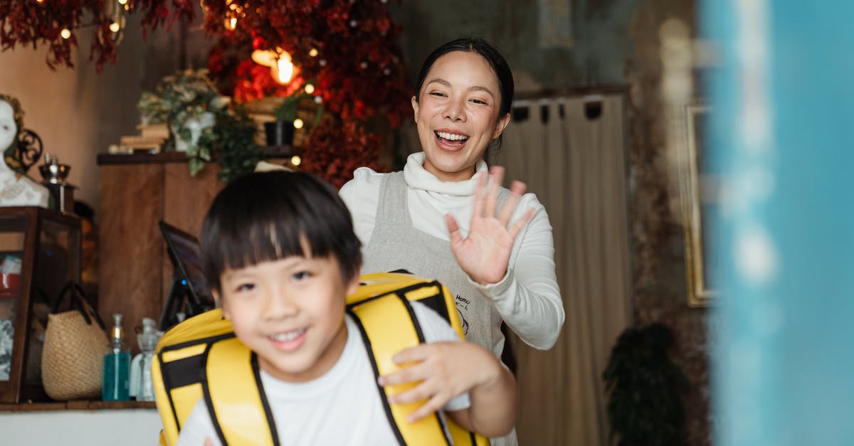 How big of a backpack should I buy? (Trans-Mongolian) - Cheerful ethnic mother saying goodbye to son with food backpack How big of a backpack should I buy? (Trans-Mongolian) - Cheerful ethnic mother saying goodbye to son with food backpack