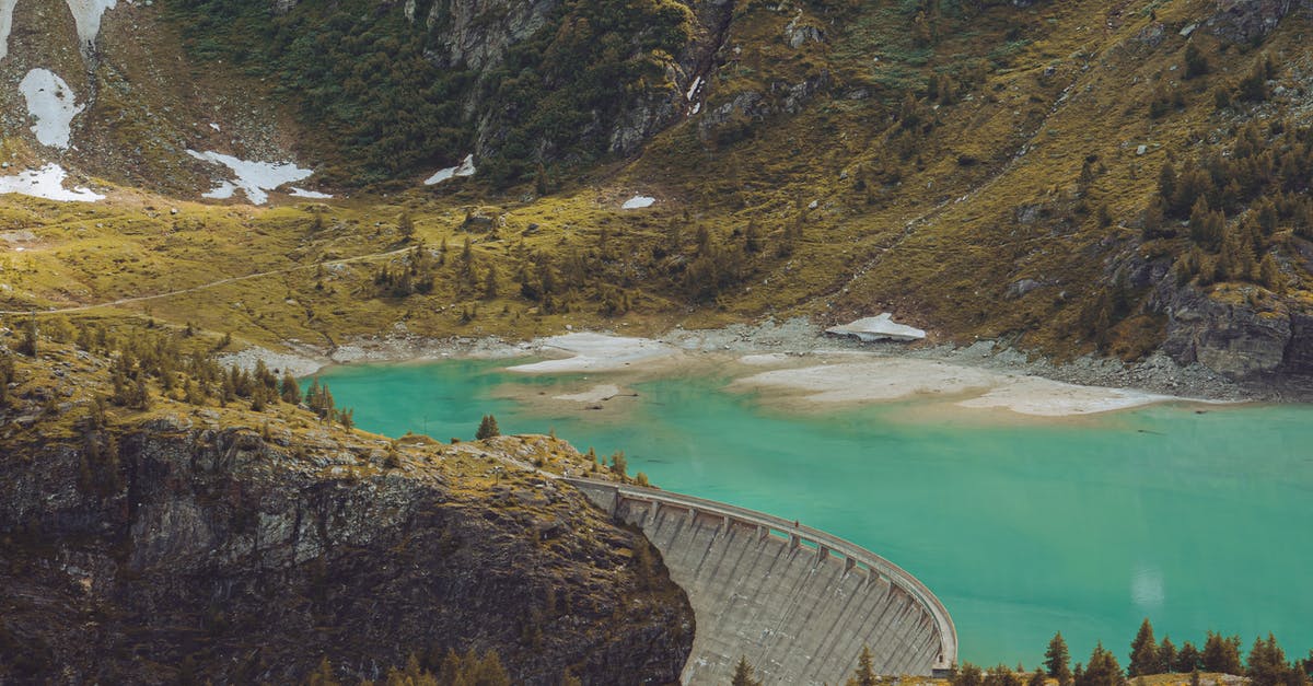 How can a Green Card holder prove their length of absence when exiting and entering through a Mexican land crossing? - Spectacular scenery of dam near azure water in mountains covered with green grass and trees in daytime