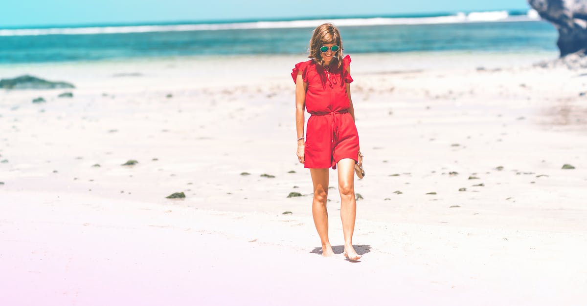 How can a person living in the tropics be better prepared to travel to snowy areas? - Woman Wearing Red Romper on Beach How can a person living in the tropics be better prepared to travel to snowy areas? - Woman Wearing Red Romper on Beach