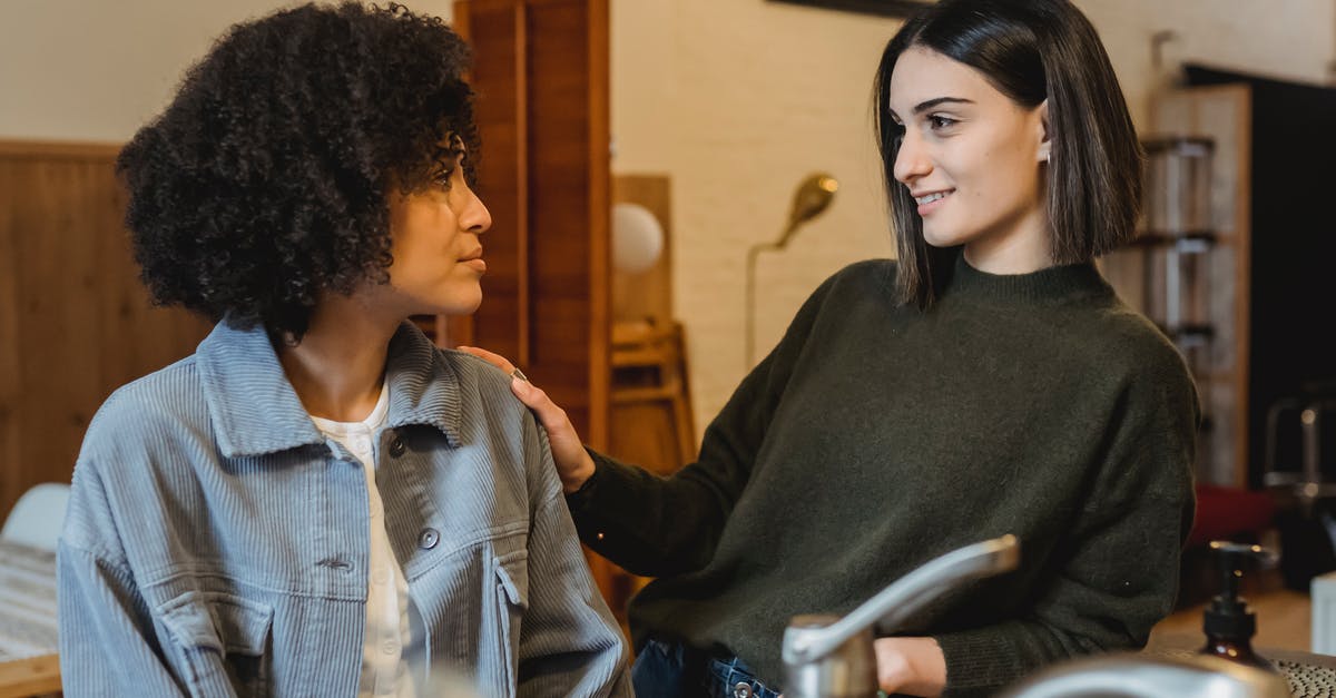 How can a traveller to Namibia best support African businesses? [closed] - Positive female stroking shoulder of upset African American female friend with Afro hairdo and looking at each other