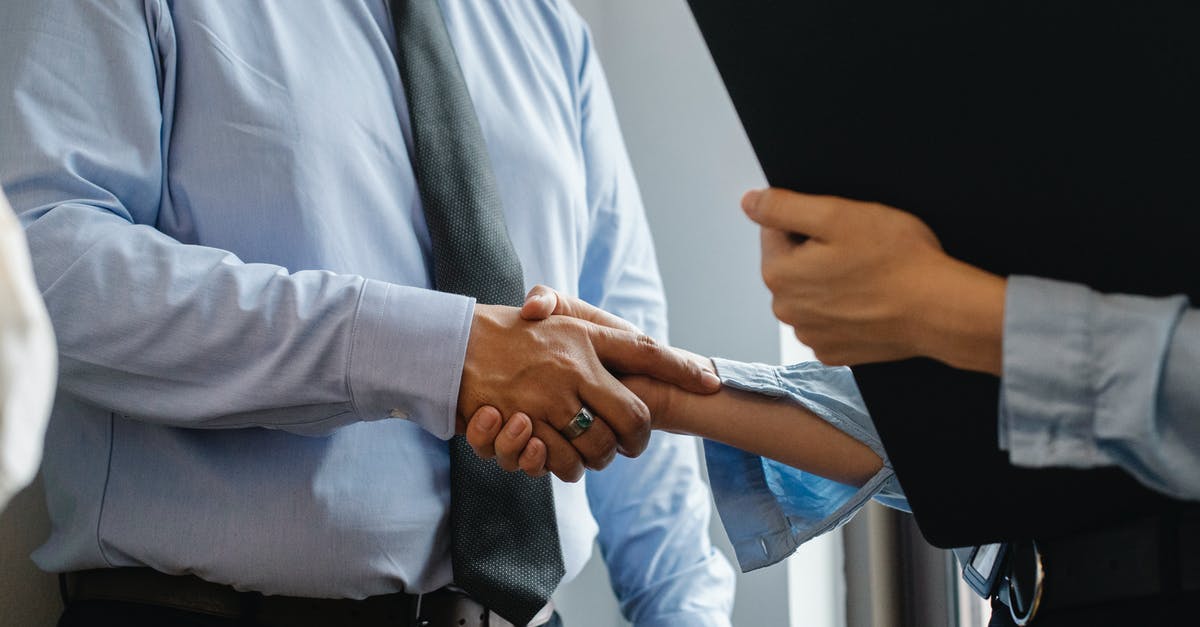How can black travellers deal with unwanted harassment from locals in China? - Crop anonymous man in formal shirt and tie shaking hand of woman with black folder while meeting in office