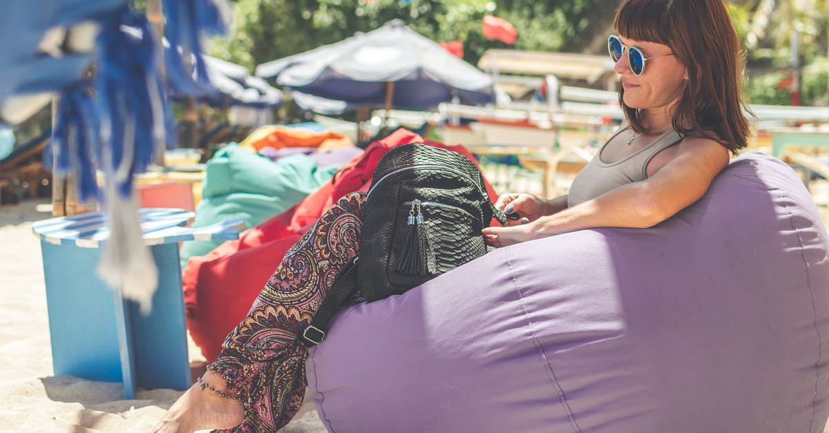 How can I assess the quality of a suitcase without relying on brand name? - Woman Wearing Gray Tank Top Sitting on Purple Bean Bag How can I assess the quality of a suitcase without relying on brand name? - Woman Wearing Gray Tank Top Sitting on Purple Bean Bag