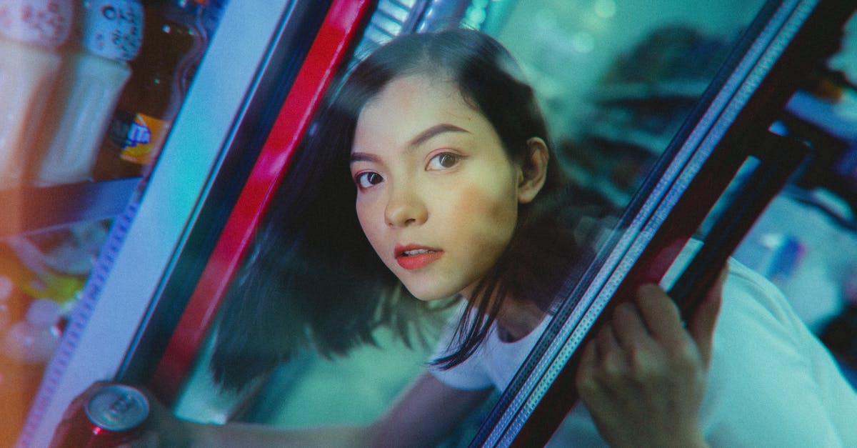 How can I avoid being overcharged when taking a cab? - Calm ethnic woman taking refreshing drink from refrigerator in shop How can I avoid being overcharged when taking a cab? - Calm ethnic woman taking refreshing drink from refrigerator in shop