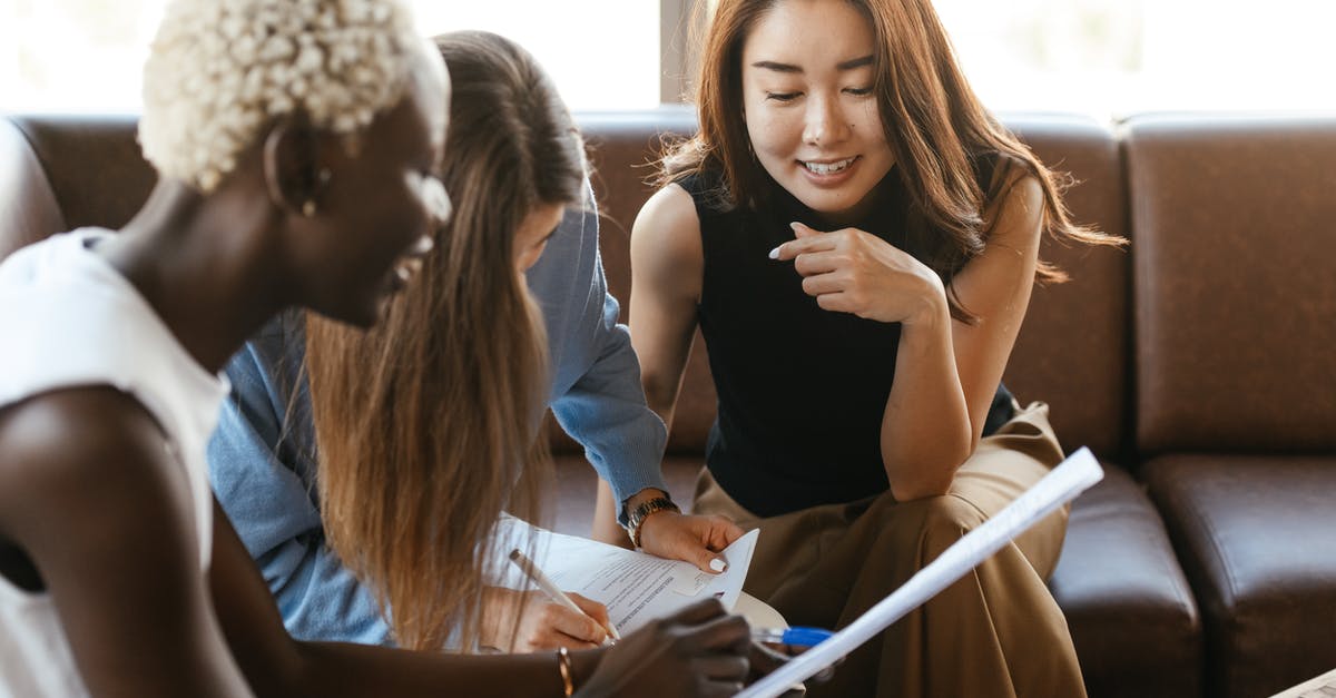 How can I check my status on an American Airlines promotion? - Multiethnic cheerful colleagues talking about job and working with documents How can I check my status on an American Airlines promotion? - Multiethnic cheerful colleagues talking about job and working with documents