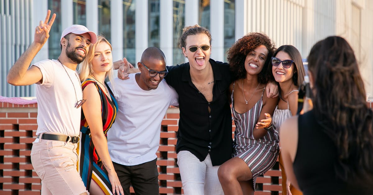 How can I find a way to climb on a rooftop in Paris and just to chill out there? - Faceless lady taking photo of positive diverse millennials during open air party How can I find a way to climb on a rooftop in Paris and just to chill out there? - Faceless lady taking photo of positive diverse millennials during open air party