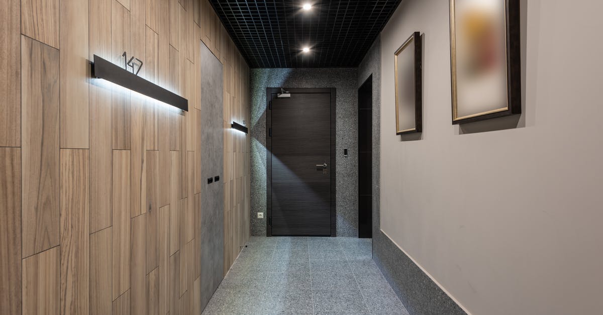 How can I find short-term private room accommodations in London? - Interior of hallway with illuminated numbers of hotel rooms hanging on wall near doors How can I find short-term private room accommodations in London? - Interior of hallway with illuminated numbers of hotel rooms hanging on wall near doors