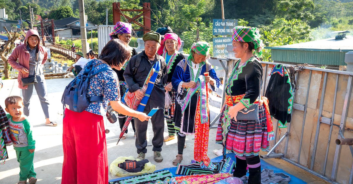How can I get people to speak the local language to me? - Ethnic vendor interacting with unrecognizable shopper in urban bazaar How can I get people to speak the local language to me? - Ethnic vendor interacting with unrecognizable shopper in urban bazaar