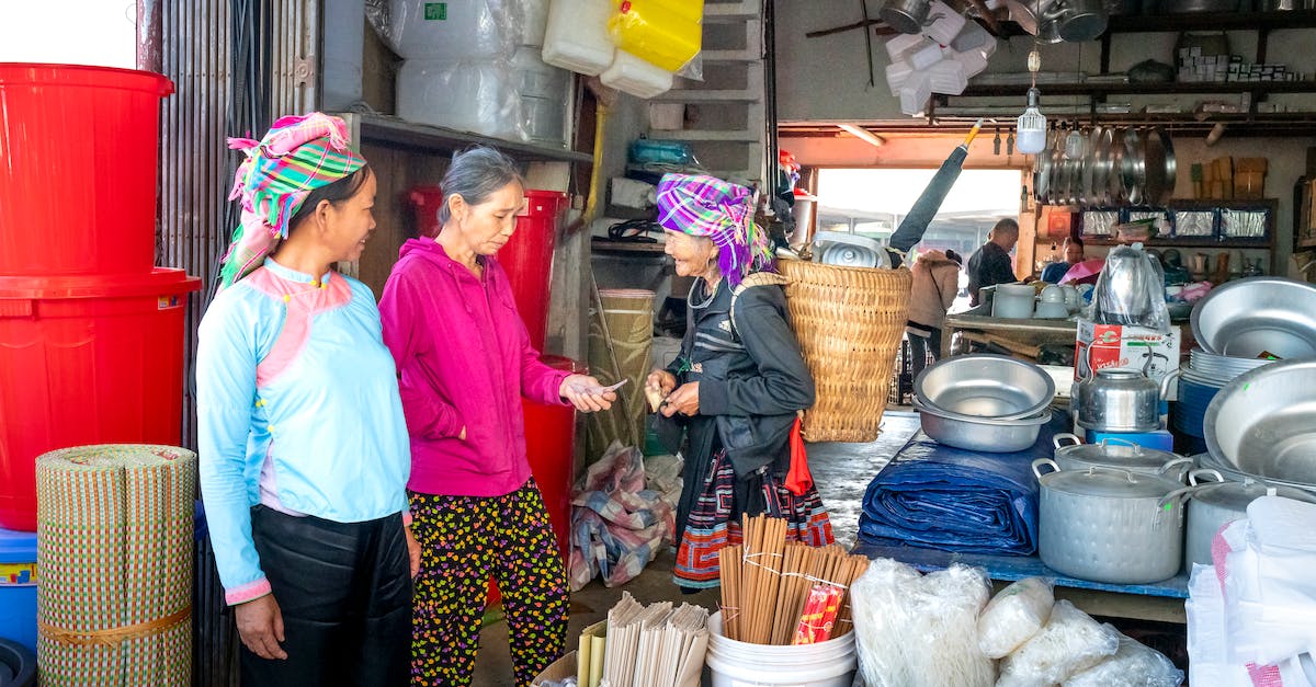 How can I get people to speak the local language to me? - Smiling Asian vendor speaking with shopper in market How can I get people to speak the local language to me? - Smiling Asian vendor speaking with shopper in market